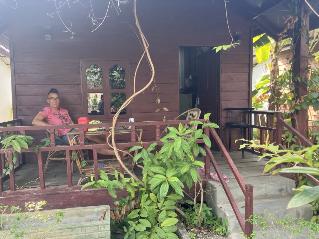 woden hut and a woman sitting on the front porch