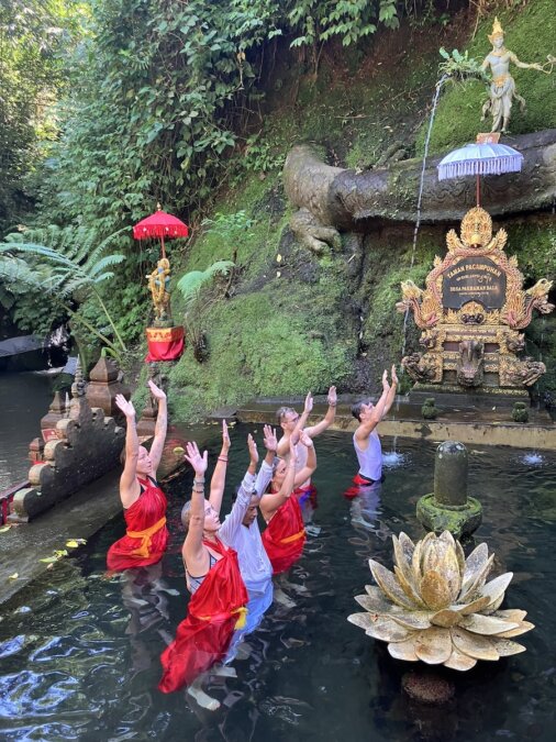 A group praying and praising during a water purification ceremony in Bali